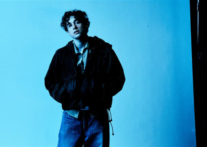 An musician called 'ThxSoMuch' posed in front of a blue backdropx